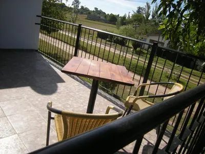 a wooden table and chairs on a balcony at 2 PAX Departamentos in Villa Rumipal