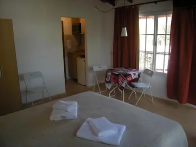 a bedroom with a bed and a table and chairs at 2 PAX Departamentos in Villa Rumipal