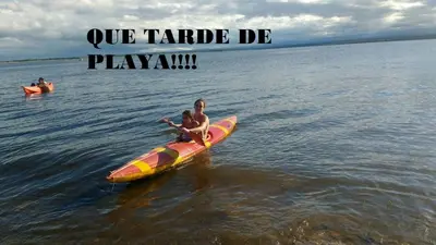 a man and a child on a surfboard in the water at 2 PAX Departamentos in Villa Rumipal