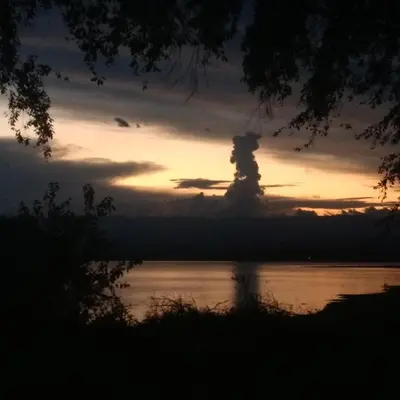 a sunset over the water with a cloud in the sky at 2 PAX Departamentos in Villa Rumipal