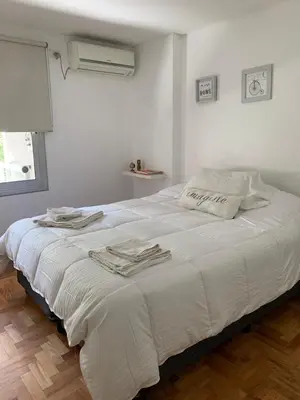 a bedroom with a white bed with towels on it at Departamentos Mediterraneo in Cordoba