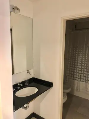a bathroom with a sink and a mirror and a toilet at Departamentos Mediterraneo in Cordoba