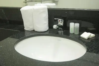 a bathroom counter with a sink with towels and a mirror at Buen Pastor Capuchinos in Cordoba