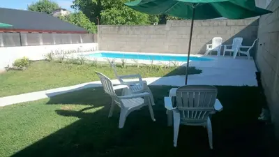 a group of chairs and an umbrella next to a pool at Cabañas Simpson in Santa Rosa de Calamuchita