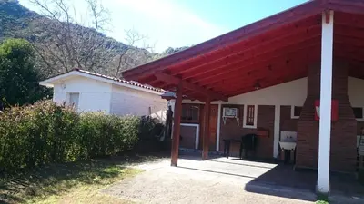a house with a red roof and a garage at Cabañas Simpson in Santa Rosa de Calamuchita