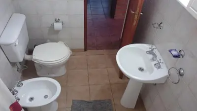 a bathroom with a toilet and a sink at Cabañas Simpson in Santa Rosa de Calamuchita
