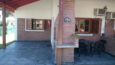 a patio with a table and chairs in a building at Cabañas Simpson in Santa Rosa de Calamuchita