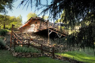 a log cabin sitting on top of a pile of rocks at El Chañar in Villa General Belgrano