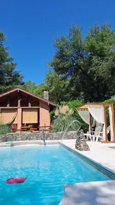 a swimming pool in front of a house at El Chañar in Villa General Belgrano