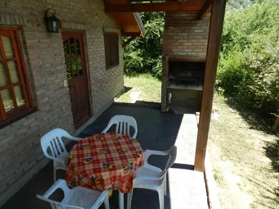 a patio with a table and chairs and a grill at Cabañas Mirasoles in Villa General Belgrano