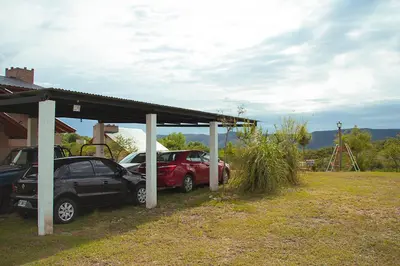 two cars parked under a shed in a yard at Complejo San Pio in Villa Icho Cruz