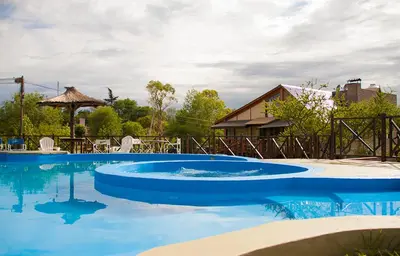 a large pool with blue water in a yard at Complejo San Pio in Villa Icho Cruz