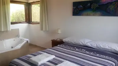 a bedroom with a bed and a bath tub at Campo de los Zorros in Nono