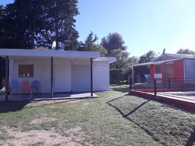 a house with a garage and a fence at Complejo Leon in Villa Rumipal