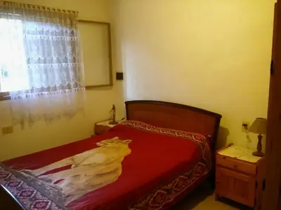 a bedroom with a red bed and a window at Complejo Leon in Villa Rumipal