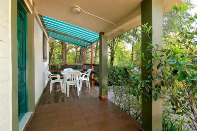 a porch with white chairs and a table on it at Cabañas Dolce Vita II in Los Reartes