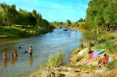 a group of people swimming in a river at Cabañas Dolce Vita II in Los Reartes