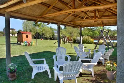 a group of white chairs sitting under a pavilion at Cabañas Dolce Vita I in Los Reartes