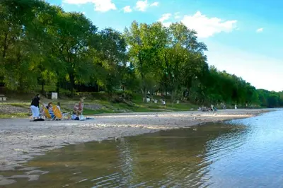 a group of people on a beach near the water at Cabañas Dolce Vita I in Los Reartes
