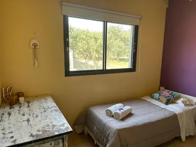 a bedroom with a bed and a window at Villa Bonita Cabañas Villa de Merlo in Merlo