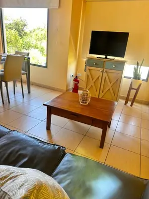 a living room with a tv and a coffee table at Villa Bonita Cabañas Villa de Merlo in Merlo