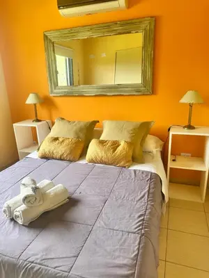 a bedroom with a large bed with a mirror on the wall at Villa Bonita Cabañas Villa de Merlo in Merlo