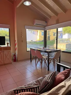 a living room with a couch and a table at Villa Bonita Cabañas Villa de Merlo in Merlo