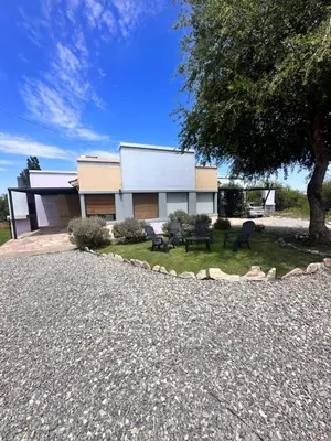 a house with a tree and a gravel driveway at Villa Bonita Cabañas Villa de Merlo in Merlo