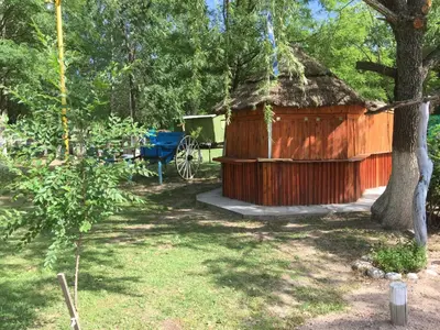 a small wooden cabin with a blue table and a cart at Hosteria Renca in Renca