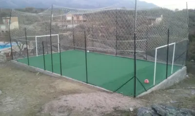 a batting cage with a tennis court on a court at Aldea Serrana in Nono