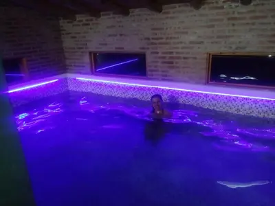a woman in a hot tub with purple lights at Aldea Serrana in Nono