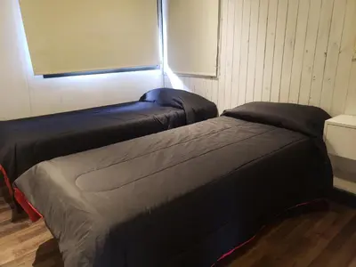 two beds sitting next to each other in a room at ViviSierras, Carlos Paz casa centro frente al lago, pileta climatizada, 4 dormitorios, 3 baños, quincho in Villa Carlos Paz