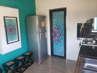 a kitchen with a stainless steel refrigerator and stools at ViviSierras, Carlos Paz casa centro frente al lago, pileta climatizada, 4 dormitorios, 3 baños, quincho in Villa Carlos Paz