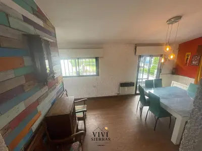 a dining room with a table and chairs and a wall at ViviSierras, Carlos Paz casa centro frente al lago, pileta climatizada, 4 dormitorios, 3 baños, quincho in Villa Carlos Paz