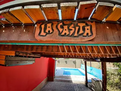 a sign on the side of a house with a swimming pool at ViviSierras, Carlos Paz casa centro frente al lago, pileta climatizada, 4 dormitorios, 3 baños, quincho in Villa Carlos Paz