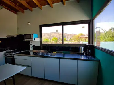 a kitchen with a sink and a large window at ViviSierras, Carlos Paz casa centro frente al lago, pileta climatizada, 4 dormitorios, 3 baños, quincho in Villa Carlos Paz