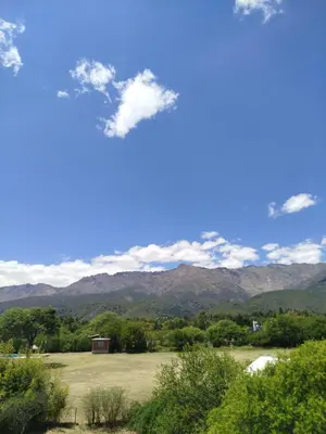 a view of a field with mountains in the background at Cabañas Entre Verde in Los Hornillos