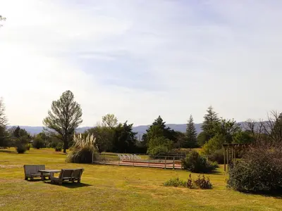 a park with two benches and a table in the grass at Posada Buen Camino in Nono