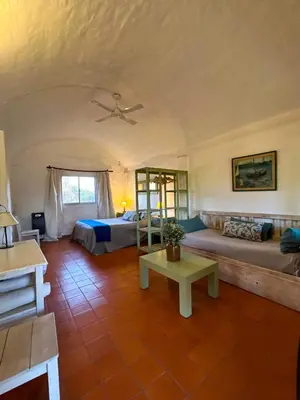 a large room with two beds and a table at Posada Buen Camino in Nono
