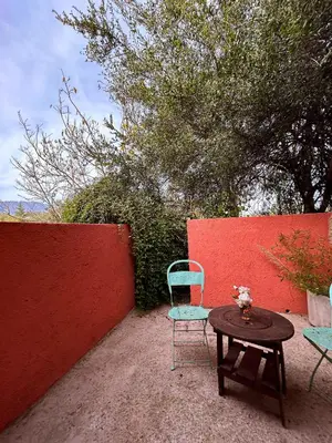 a table and a chair sitting next to a red wall at Posada Buen Camino in Nono