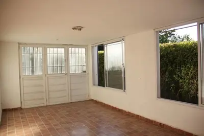 an empty room with two doors and two windows at Casa en Balneario Sol y Rio in Villa Carlos Paz