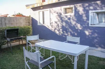 a white table and chairs in front of a building at Casa en Balneario Sol y Rio in Villa Carlos Paz