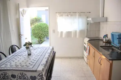 a kitchen with a table with a vase of flowers on it at Casa en Balneario Sol y Rio in Villa Carlos Paz