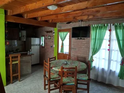 a kitchen and dining room with a table and chairs at Cabañas Terra Natura in Bialet Massé