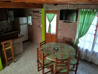 a kitchen and dining room with a table and chairs at Cabañas Terra Natura in Bialet Massé