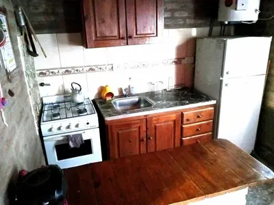 a kitchen with a sink and a white refrigerator at Cabañas Terra Natura in Bialet Massé