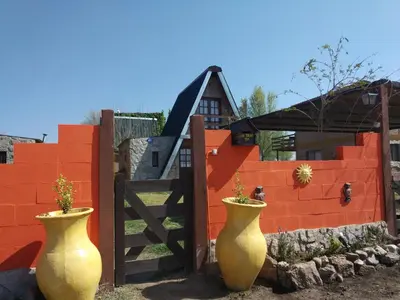 two large vases sitting in front of a fence at Cabañas Terra Natura in Bialet Massé