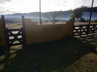 a wooden fence with a view of a field at Cabañas Terra Natura in Bialet Massé