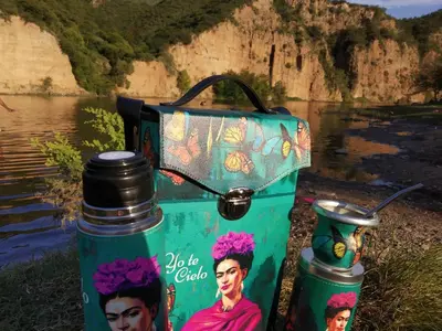 two water bottles and a thermos next to a body of water at Cabañas Terra Natura in Bialet Massé