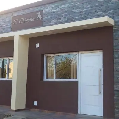 a building with a white door and a sign on it at El Chinchero Departamentos in Merlo